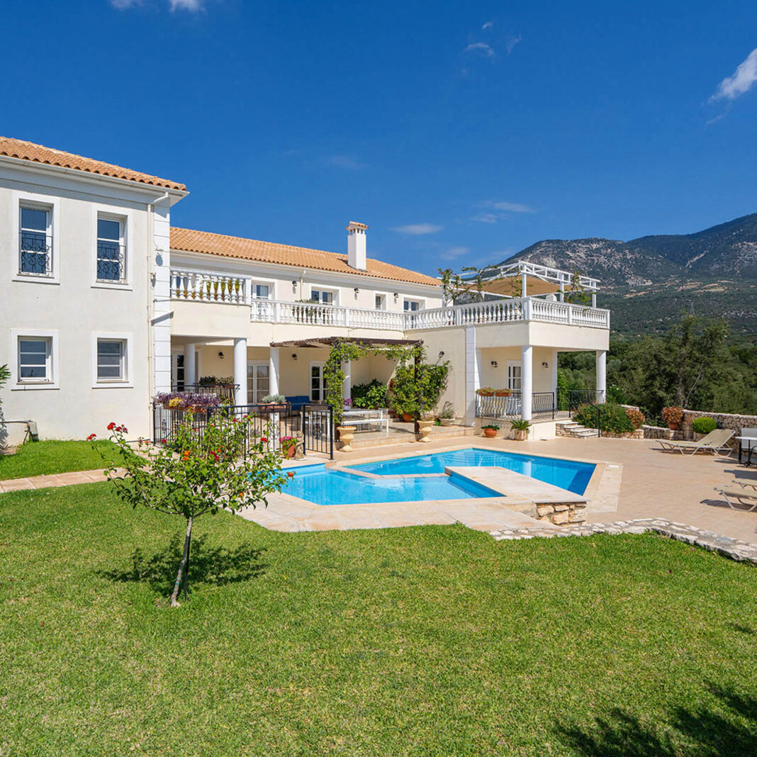 Pool view at Villa Loukia, Kefalonia showcasing the large garden, blue skies and mountain views